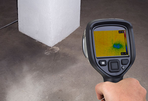 hand holding a digital inspection tool pointing at the floor as part of a chimney inspection