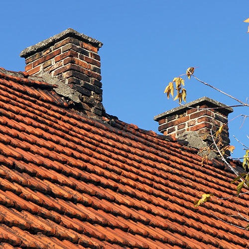 Chim Chimney Sweep Stock Image of Damaged Double Chimney View of roof with two chimneys both with damaged masonry on a tile roof